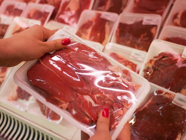 Image of packaged meat with woman hand in the supermarket