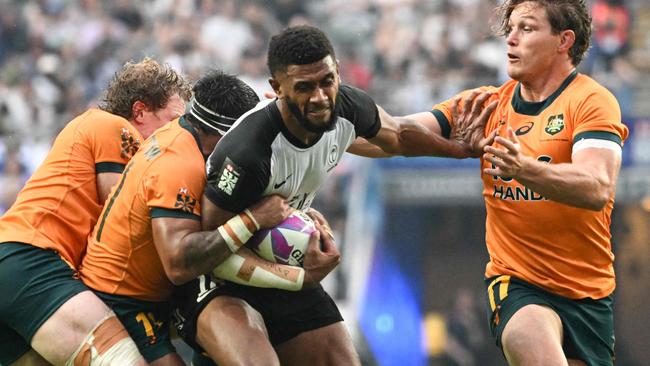 Fiji's Ponipate Loganimasi (C) fends off Australiaâs Michael Hooper (R) in their Pool A match at the 2024 Rugby Sevens Hong Kong tournament at the Hong Kong stadium on April 5, 2024. (Photo by Peter PARKS / AFP)