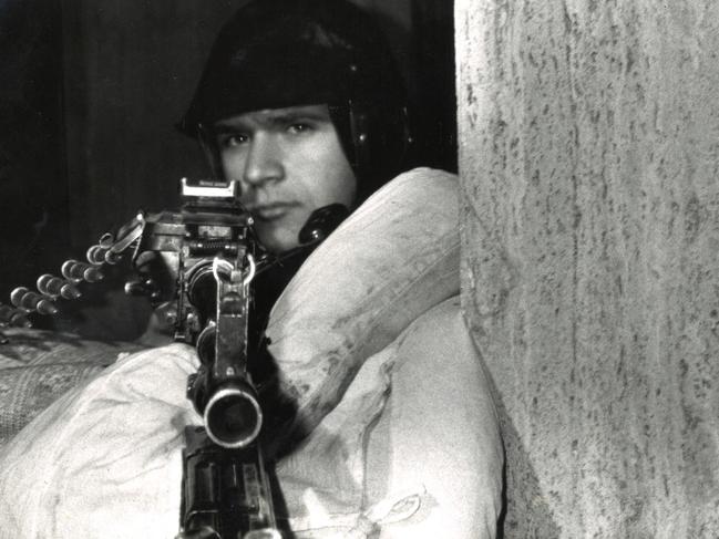 TAUS 60th Anniversary. A Romanian soldier braves the freezing winter weather wrapped in a doona looking down the sight of his rifle. Picture: Hedley Thomas