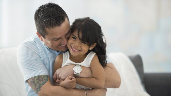 A father is giving his daughter a hug on father's day.