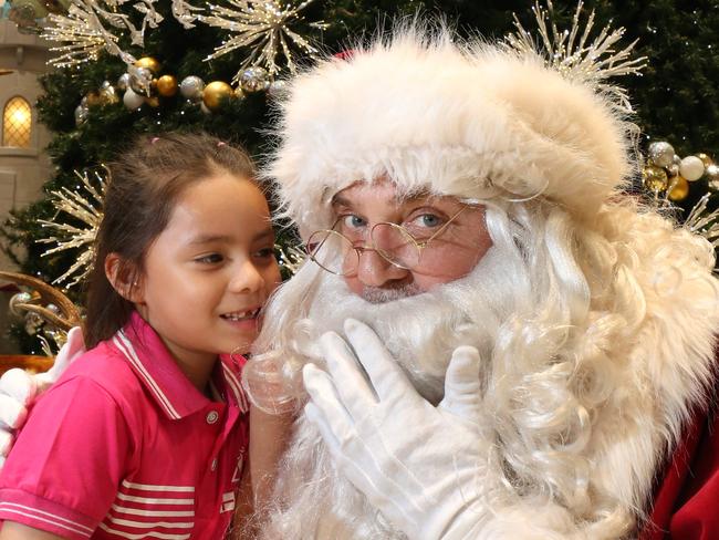 Cristina Diaz, 6, whispers into Santa’s ears. Picture: Robert Pozo