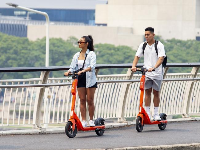 EMBARGO FOR TWAM 29 MAY 2021 People riding Neuron e-scooters through Brisbane, Sunday, December 22, 2019 (AAP Image/Richard Walker)