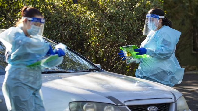 Nurses are seen testing residents for Covid at a drive-thru fever clinic in Ipswich in August. Picture: Getty Images