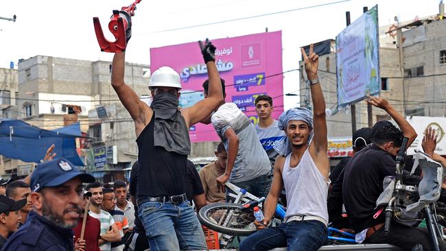 Palestinians celebrate their return after crossing the border fence with Israel from Khan Yunis in the southern Gaza Strip on October 7, 2023. Barrages of rockets were fired at Israel from the Gaza Strip at dawn as militants from the blockaded Palestinian enclave infiltrated Israel, with at least one person killed, the army and medics said. (Photo by SAID KHATIB / AFP)