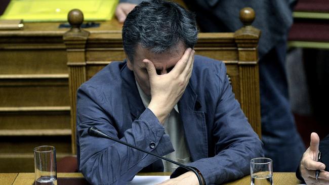 Greek Finance Minister Euclid Tsakalotos gestures as he attends a parliament session in Athens, on July 15, 2015. Greece geared up for a parliamentary vote on draconian reforms demanded by eurozone creditors in exchange for a huge new bailout, just hours after a bombshell report from the International Monetary Fund criticised the deal. AFP PHOTO / ANGELOS TZORTZINIS