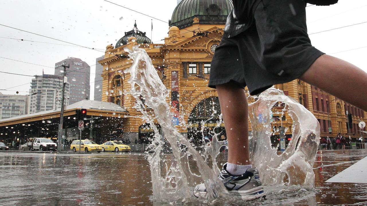 Winter wet weather to stay for a while in Melbourne. Rain. Splash down as people battle the rain and puddles outside Flinders Street Station.