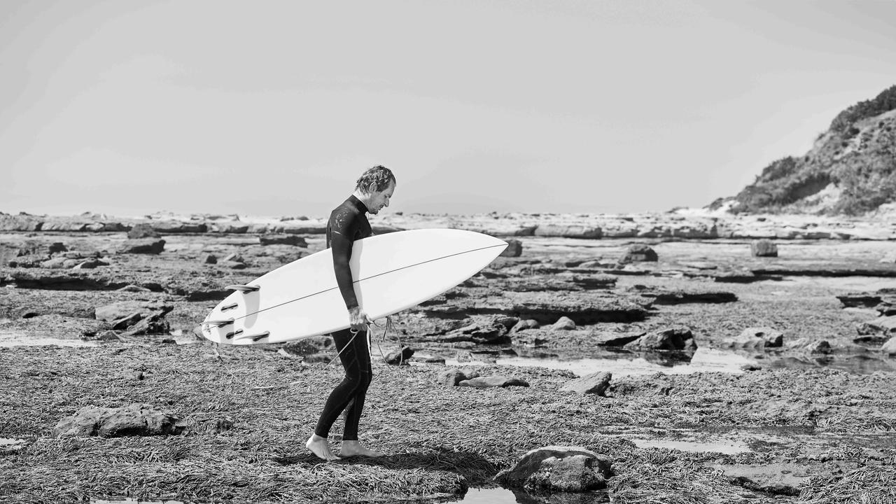 “I learned to surf all around here,” he says, gesturing at the coastline, the Wollongong city skyline visible behind him. “There is something about the natural beauty... It’s where the escarpment meets the sea. And that’s what makes it dramatic. And that’s what makes it dark, in a good way, too.” Picture: Nic Walker