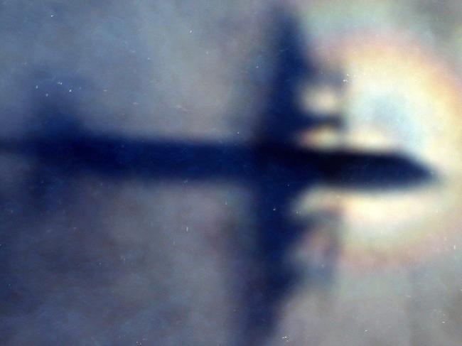 FILE - In this March 31, 2014 file photo, the shadow of a Royal New Zealand Air Force P3 Orion is seen on low level cloud while the aircraft searches for missing Malaysia Airlines Flight MH370 in the southern Indian Ocean, near the coast of Western Australia. The director of a seabed hunt for Malaysia Airlines Flight 370 on Tuesday, May 22, 2018, disagreed with a new book's conclusion that the pilot likely flew the plane beyond the search area to deliberately sink it in unexplored depths of the Indian Ocean.(AP Photo/Rob Griffith, File)