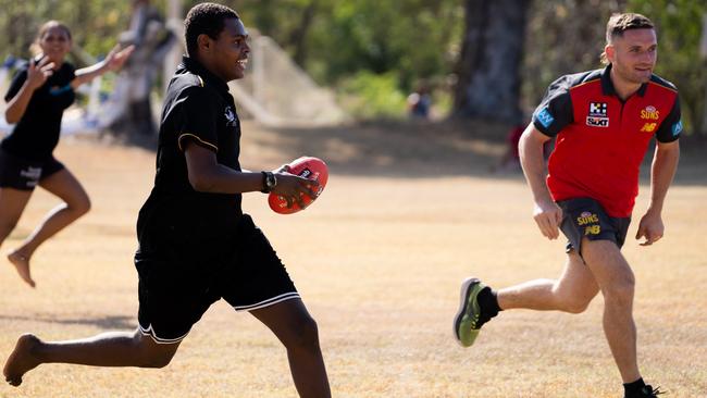 James Tsitas playing footy with students from the Jabiru Area School. Picture: Supplied.