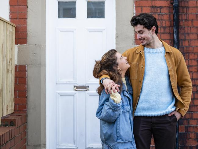 A medium close up view of a young couple stood outside of their new home in Whitley Bay. They are stood affectionately and smiling at each other.first-home buyer stock photo from istock for herald sun realestate