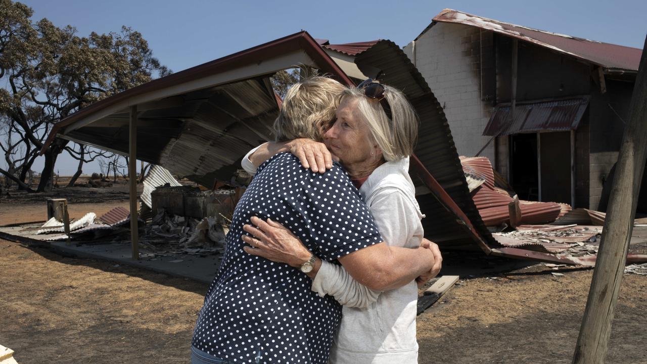 Kate Stanton and Helen Wurst at the Stokes Bay Community Hall, destroyed in Friday’s bushfires. Picture: AAP / Emma Brasier