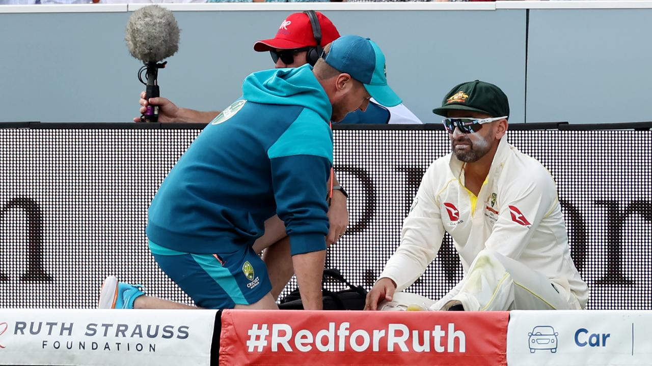 Nathan Lyon is assessed for a calf injury suffered on day two. Picture: Getty