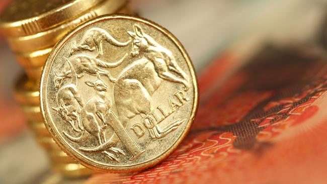 Australian one dollar coin sitting on a twenty dollar note. money coins dollars generic