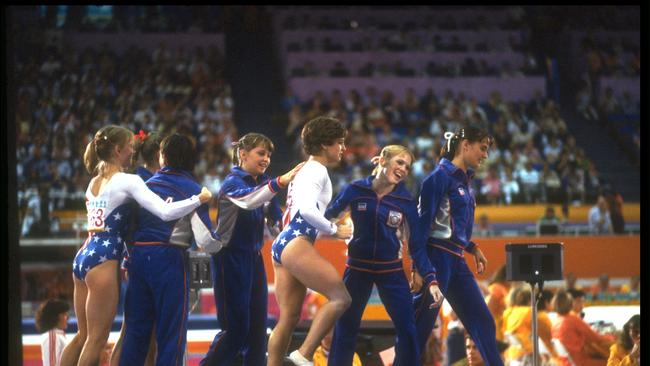Mary Lou Retton is congratulated by teammates after scoring a perfect 10.0 on the vault in the team event in 1984.