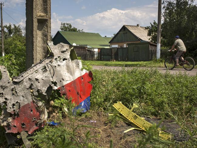 A man cycles past a piece of the wreckage of Malaysia Airlines flight MH17 in Petropavlivka, Ukraine. Picture: Rob Stothard/Getty Images