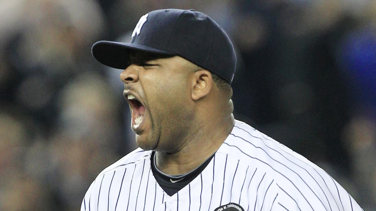 New York Yankees starting pitcher CC Sabathia wipes his face on