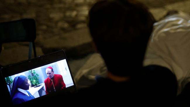 A man watches the movie Conclave on his laptop as he waits near the Vatican to attend late Pope Francis' funeral in Rome on April 26. Picture: Henry Nicholls/AFP