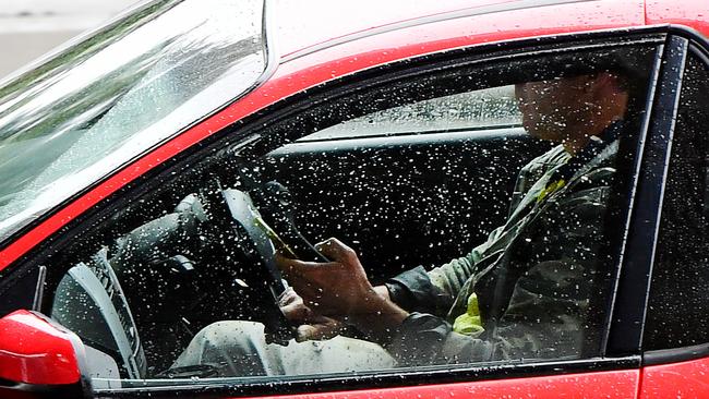 A driver using a mobile phone on South Rd at Black Forest. Picture: Mark Brake/AAP