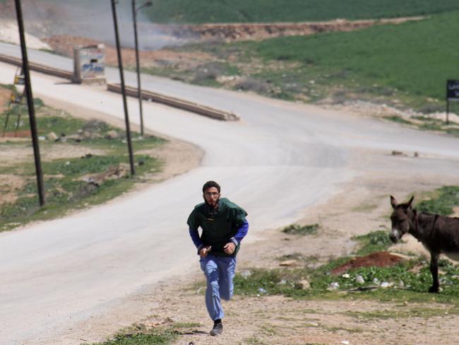 A Syrian medic runs for cover during the air strikes which hit a hospital in Khan Sheikhun, a rebel-held town in the northwestern Syrian Idlib province. Picture: AFP/Omar haj kadour