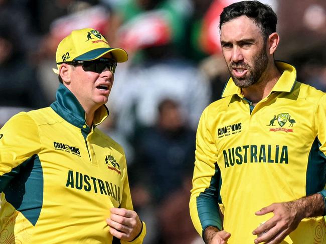 Australia's Glenn Maxwell (R) speaks with captain Steve Smith during the ICC Champions Trophy one-day international (ODI) cricket match between Australia and England at the Gaddafi Stadium in Lahore on February 22, 2025. (Photo by Aamir QURESHI / AFP)