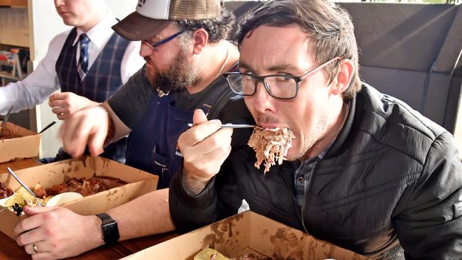 Hills Shire Times reporter Gary Hamilton-Irvine undertaking the challenge of eating 2kg of brisket, pork, hot links, slaw, mac ÔnÕ cheese, beans, pickle and crisps in under 15 minutes. (AAP IMAGE / Troy Snook)