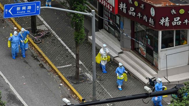 Health workers wearing personal protective equipment arrive at a neighbourhood in Shanghai. Picture: AFP