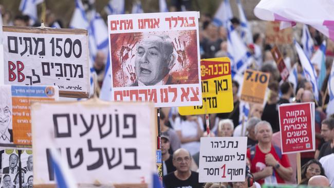 Protesters hold signs during a demonstration against the Israeli Prime Minister Benjamin Netanyahu.