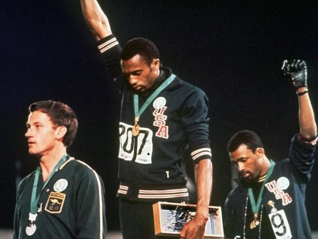 FILE - In this Oct. 16, 1968, file photo, extending gloved hands skyward in racial protest, U.S. athletes Tommie Smith, center, and John Carlos stare downward during the playing of national anthem after Smith received the gold and Carlos the bronze for the 200 meter run at the Summer Olympic Games in Mexico City. Australian silver medalist Peter Norman is at left. The U.S. Olympic and Paralympic Committee is signaling willingness to challenge longstanding IOC rules restricting protests at the Olympics, while also facing backlash from some of its own athletes for moves viewed by some as not being driven by sufficient athlete input. (AP Photo/File)