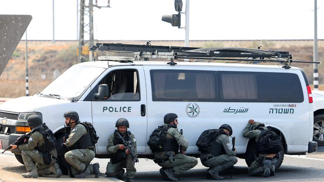 Israeli security forces take cover during a rocket attack near the southern city of Sderot. Picture: AFP