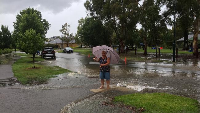 Pakenham resident Samantha Thorpe standing in her flooded driveway at Henry Lawson Drive in Melbourne. Picture: Supplied