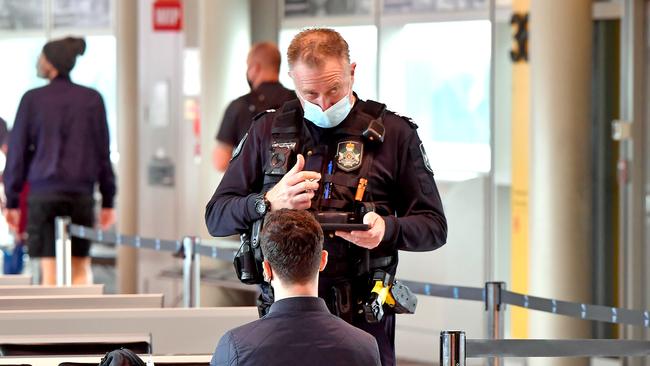 Police talk to passengers from incoming flights from Sydney at Brisbane Domestic Airport as Queensland shuts its borders to NSW. Picture: NCA NewsWire / John Gass