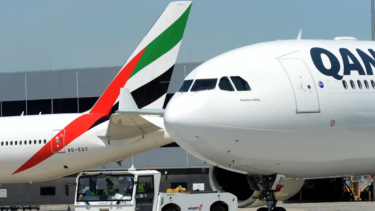 A Qantas and an Emirates plane taxi past each other at Melbourne Airport. Picture: NCA NewsWire / Andrew Henshaw