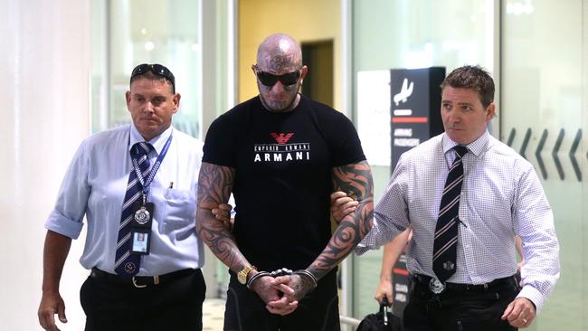 Brett "Kaos" Pechey arriving at Brisbane International airport in custody.