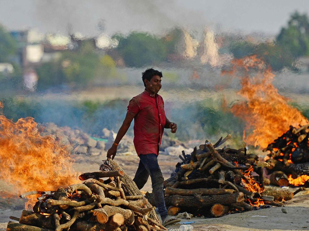 Funeral pyres burn as the last rites are performed of the patients who died of the Covid-19 coronavirus at a cremation ground in Allahabad on April 27, 2021. (Photo by SANJAY KANOJIA / AFP)