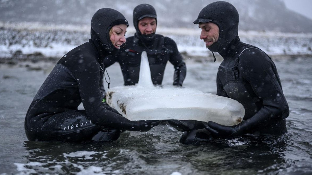 The surfers had to work quickly to use the boards before they melted. Picture: AFP