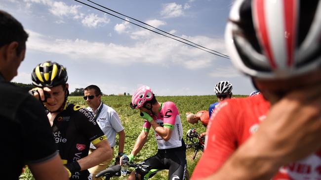 Riders clean their eyes after tear gas was used during a farmers' protest during Tuesday’s Tour de France 16th stage between Carcassonne and Bagneres-de-Luchon.