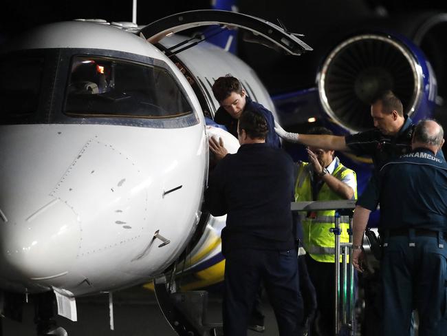 The injured workers arrive in Brisbane aboard an aeromedical flight. (AAP Image/Josh Woning)