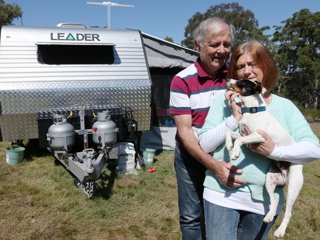 Darren and Elizabeth and Vos (with their dog Banjo) lost their home and now live in a caravan as a result of their losses. Picture: Adam Taylor