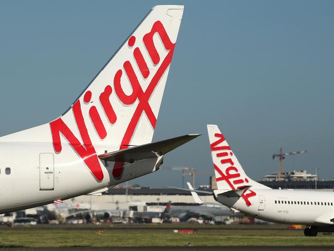 The Virgin Australia Holdings Ltd. logo is displayed on the tails of a Boeing Co. 737-800, left, and a Boeing Co. 737-8FE aircraft preparing to take off at Sydney Airport in Sydney, Australia, on Monday, Feb. 8, 2016. Virgin Australia is scheduled to announce half-year earnings on Feb. 11. Photographer: Brendon Thorne/Bloomberg