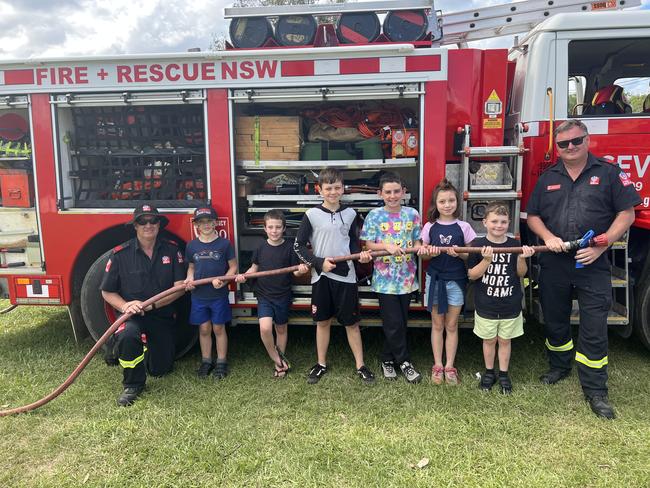 Firefighter Kenny Harrison, Ashton Smith, Riley Nash, Jarrah Robinson, Ryder Davies, McKenzie Robinson, Dexter Robinson and Firefighter Dean Wilson (left to right) pose in front of the Fire + Rescue NSW truck for the 120th Murwillumbah Show. Picture: David Bonaddio