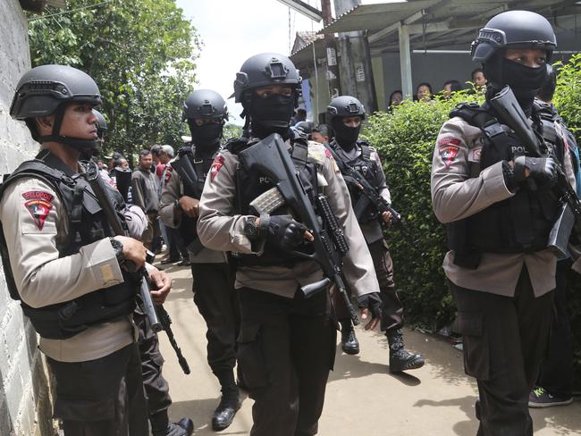 Police officers stand guard at a residential neighborhood where police conducted a raid on a house used by suspected militants, in Tangerang, Indonesia. Picture: AP