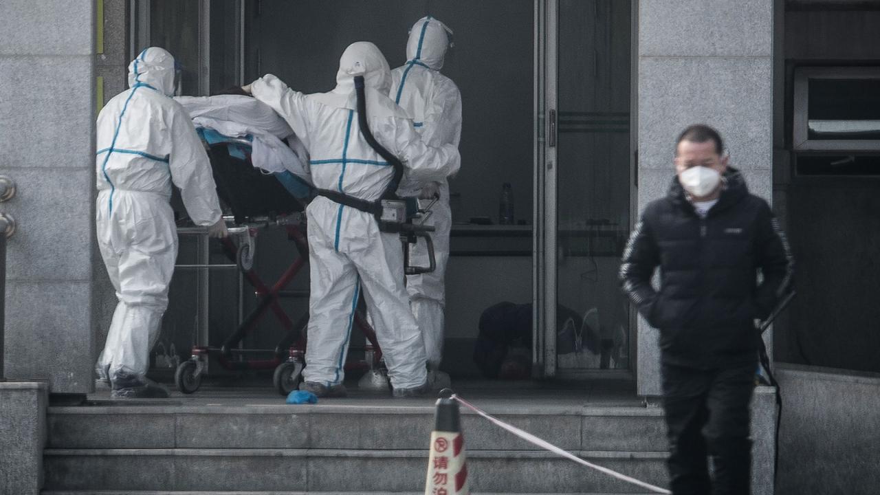 Medical staff members carry a patient into the Jinyintan hospital, where patients infected by coronavirus are being treated. Picture: STR/AFP