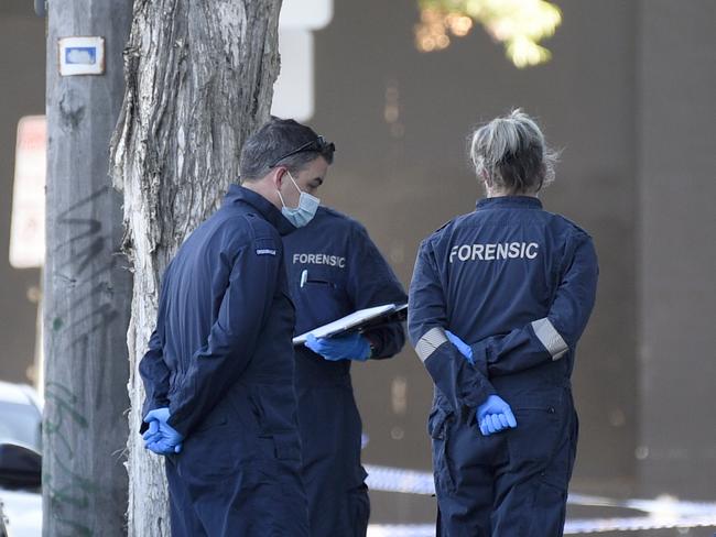 Forensics police examine the scene at Langford Street North Melbourne. Picture: Andrew Henshaw