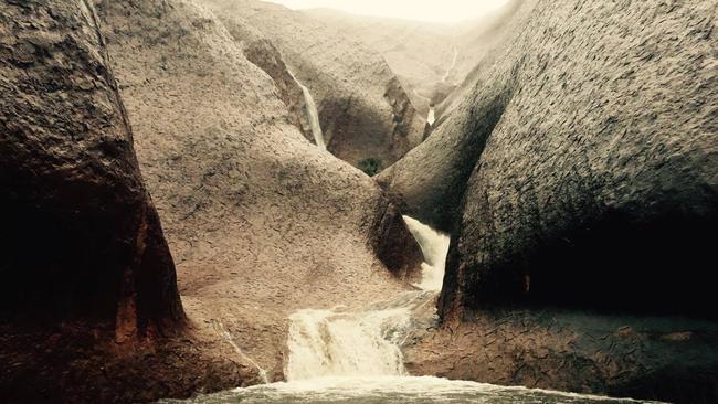 Water is streaming down Uluru after heavy rain. Picture: Jared Strachan