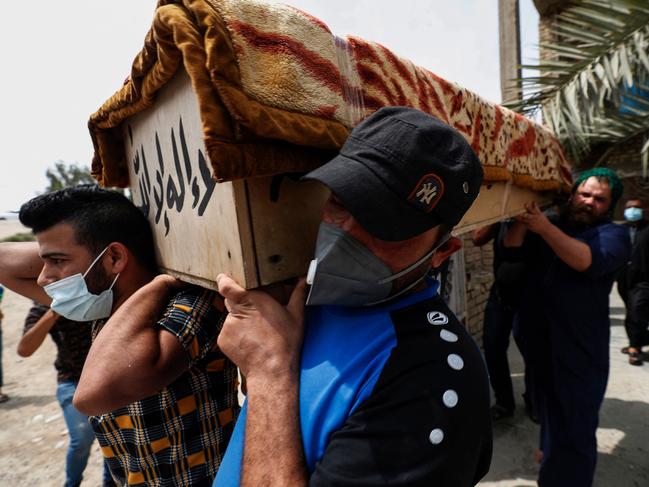 Iraqis transport the coffin of a relative who was killed during a fire at the Ibn al-Khatib hospital. Picture: AFP