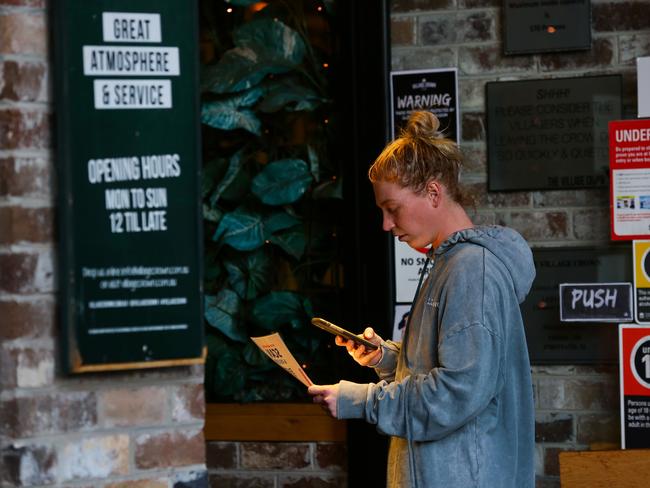 A young woman scans a QR code to sign in to a pub. Picture: NCA NewsWire/Gaye Gerard