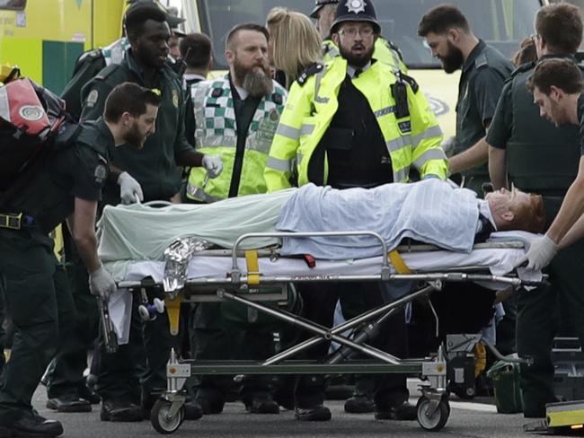 Emergency services staff provide medical attention to injured people on the south side of Westminster Bridge, close to the Houses of Parliament in London. Picture: AP