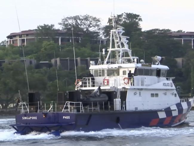 A Singapore police coast guard vessel patrols the waters off Sentosa in front of the  summit venue, the Capella Hotel.