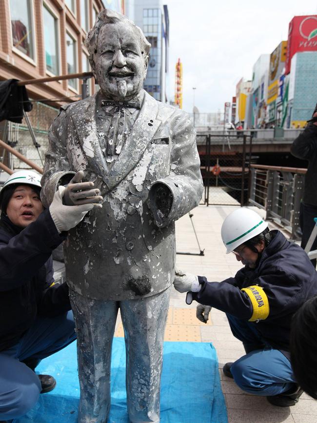 Workers hold together a statue of Colonel Sanders after it was fished out of the Dotonbori River.