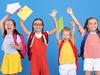Funny kids classmates with backpacks jumping on blue background from happiness on first school day, raising hands up with exercise books, boys and girls excited to be back at school after vacation